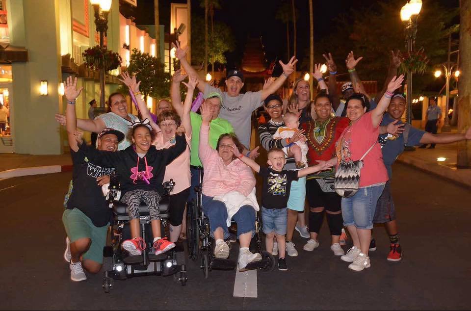 Large family with grandparents in wheelchairs smiling at Hollywood Studios