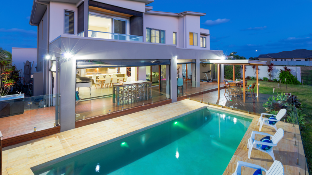 Inviting backside of a Florida vacation home with a lit patio and pool.