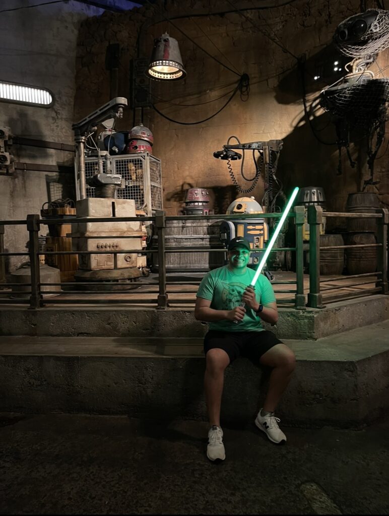 Young man holding a lightsaber at Disney's Hollywood Studios Star Wars Galaxy's Edge.