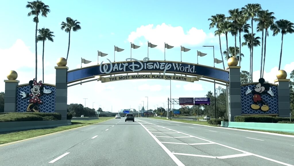 The 'Welcome to Walt Disney World' arch over the expressway in Orlando, Florida, inviting visitors to explore its magical theme parks.