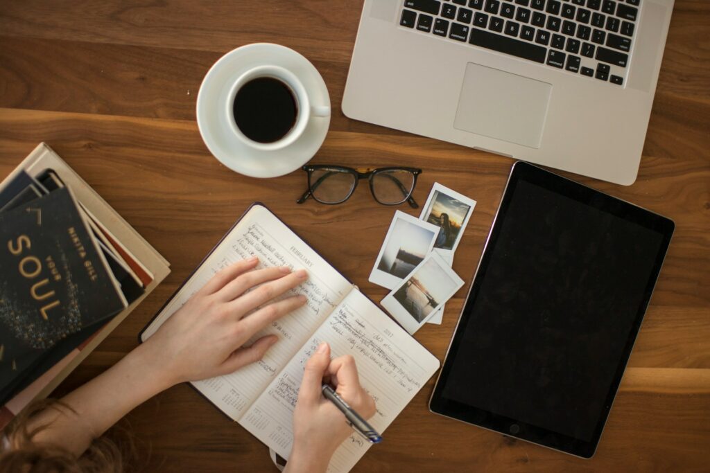 Person planning a Florida vacation with maps, budget lists, and a laptop on a desk